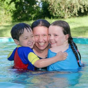 A woman and two children in a pool
